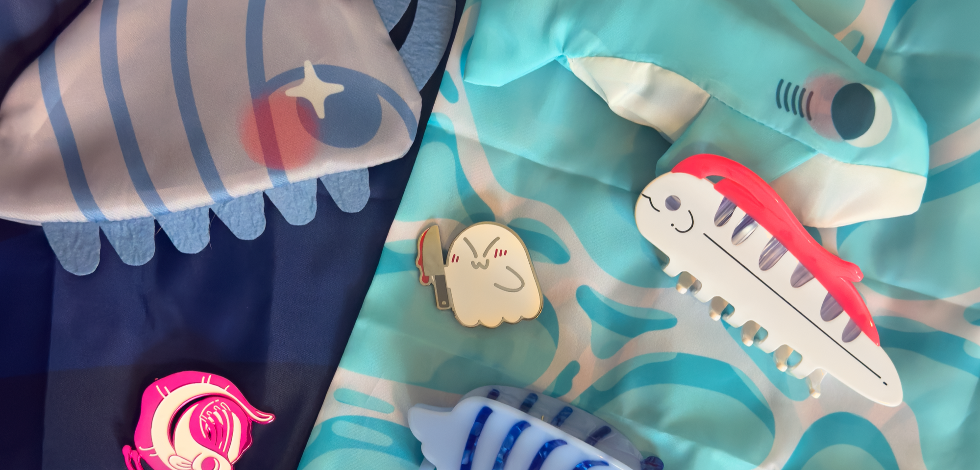 Children's clothing with shark and fish designs on a blue background
